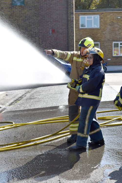 Student using a hose pipe spraying water