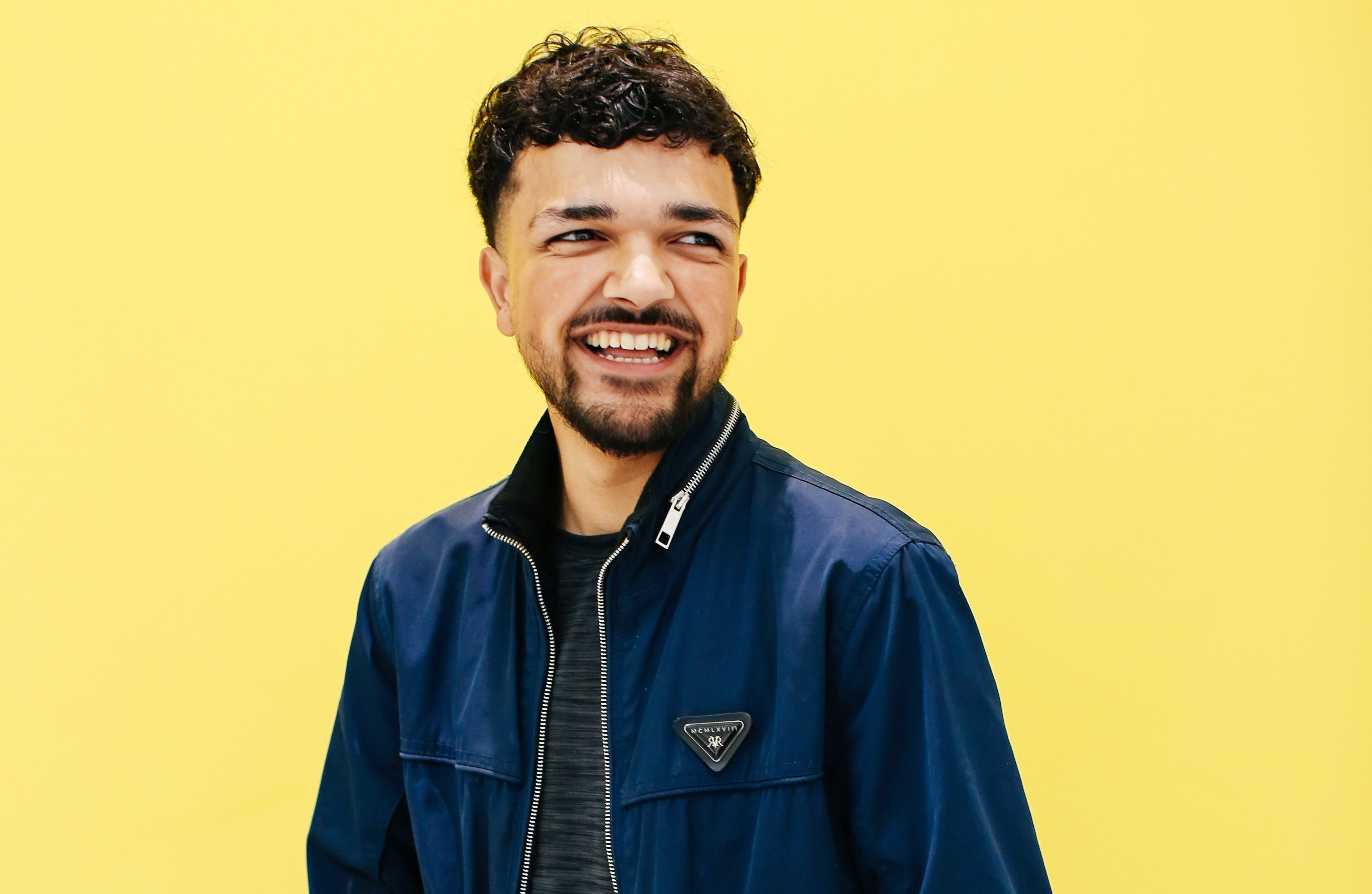 student smiling holding a laptop