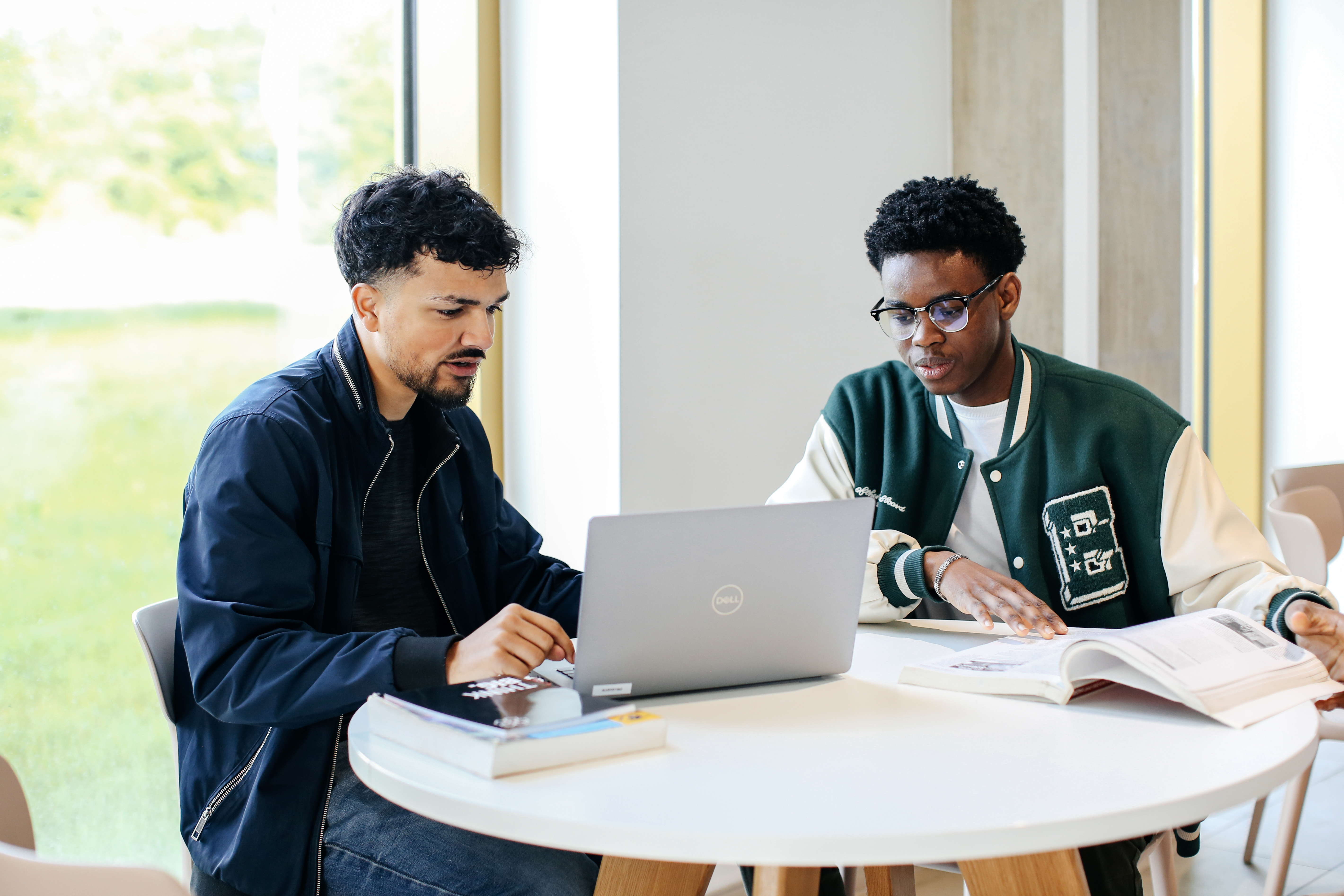 students sat around a laptop
