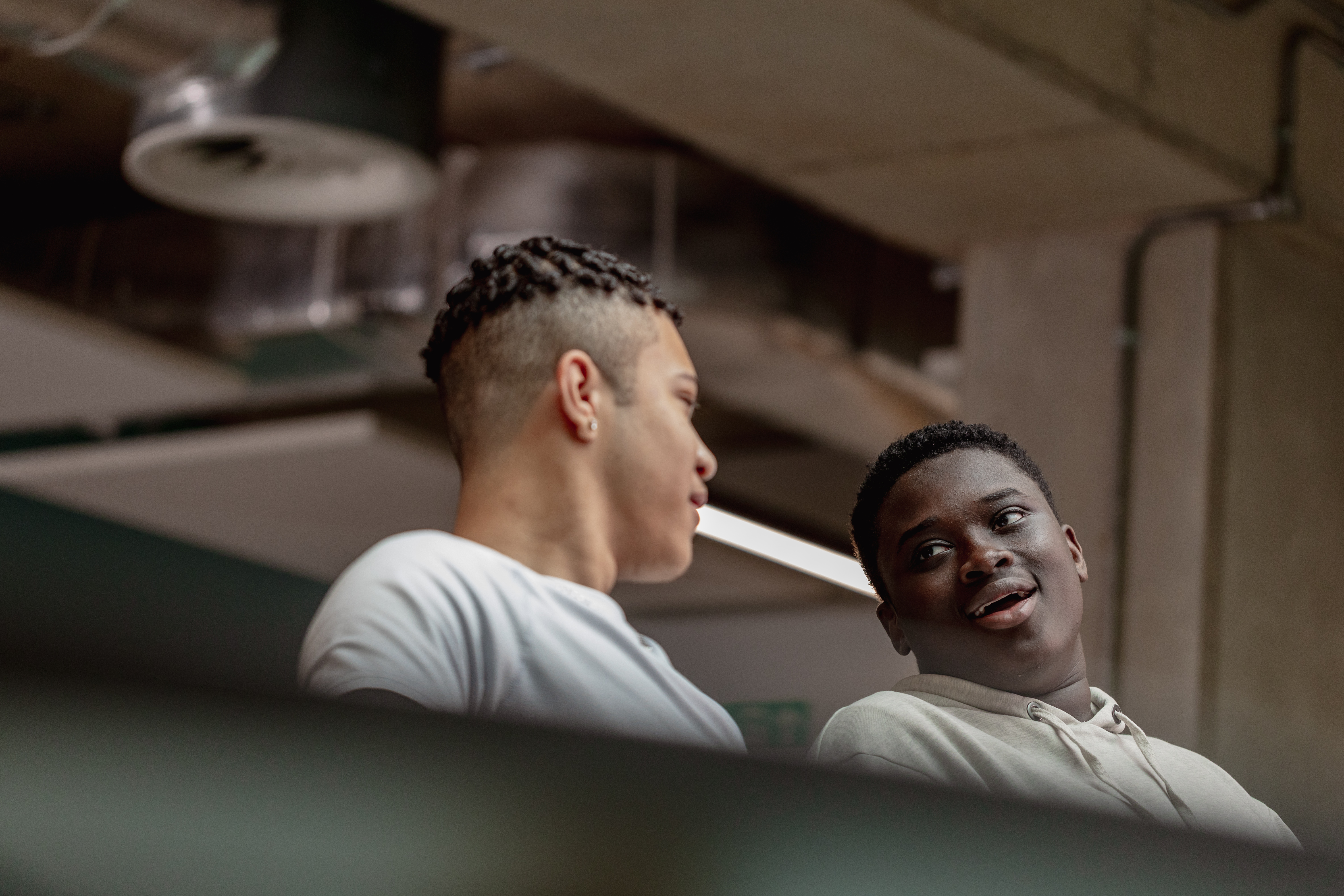 Two students sitting chatting to one another