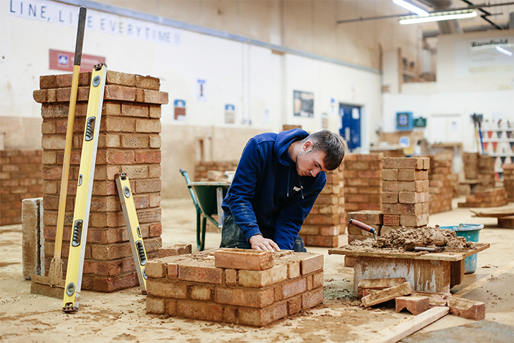 Placing bricks on a wall