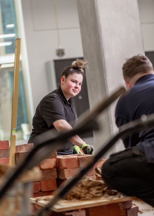 Student working with cement and bricks