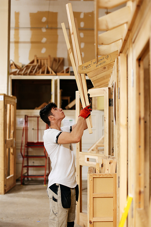 Student adding wooden piece to work