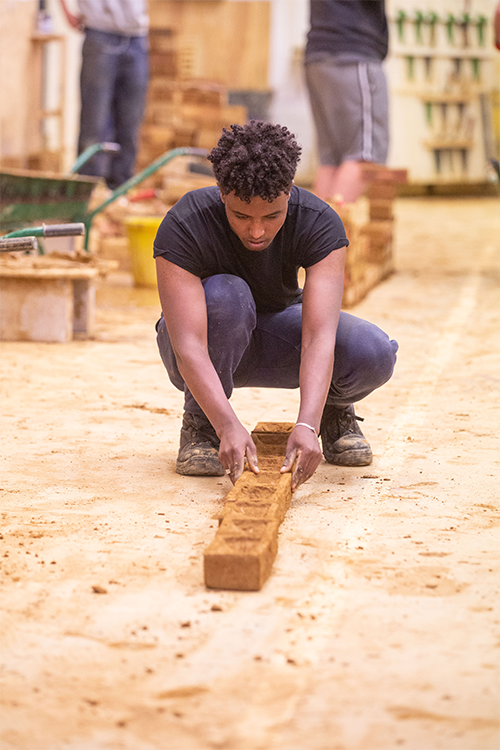 Student beginning a brick wall