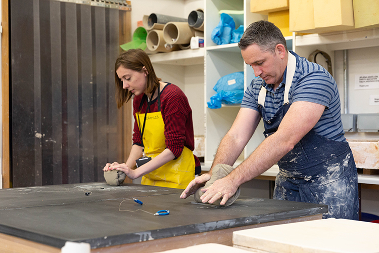 2 students creating a pottery project