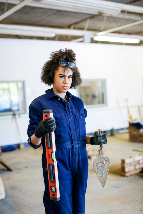 Girl holding sprit level and trowel