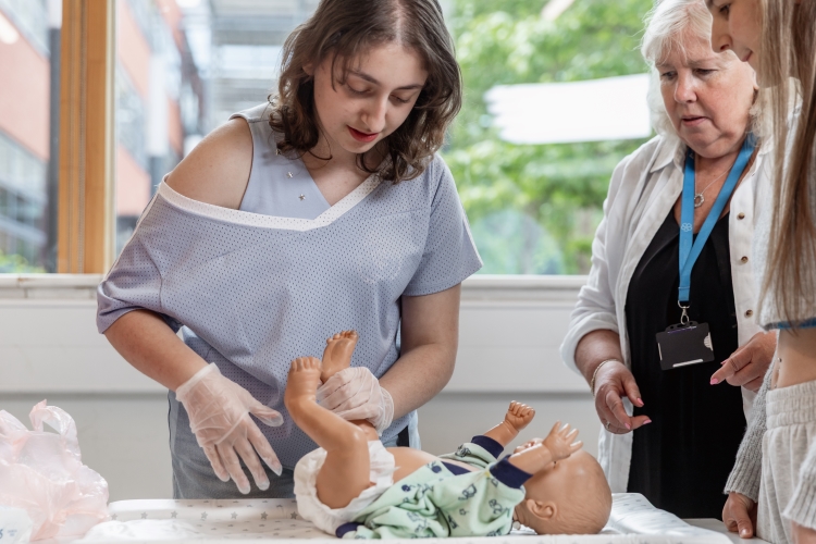 Tutor observing students doing a demonstration
