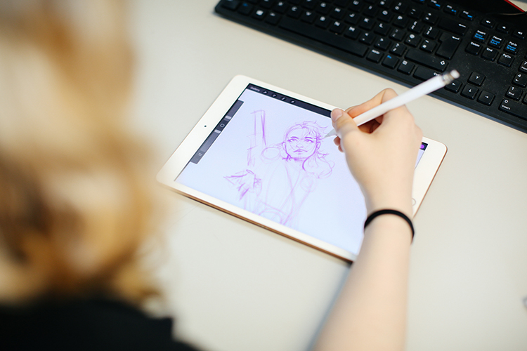 Girl using tablet to design a digital illustration