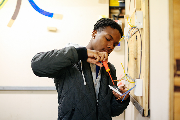 Student fixing a light switch wiring