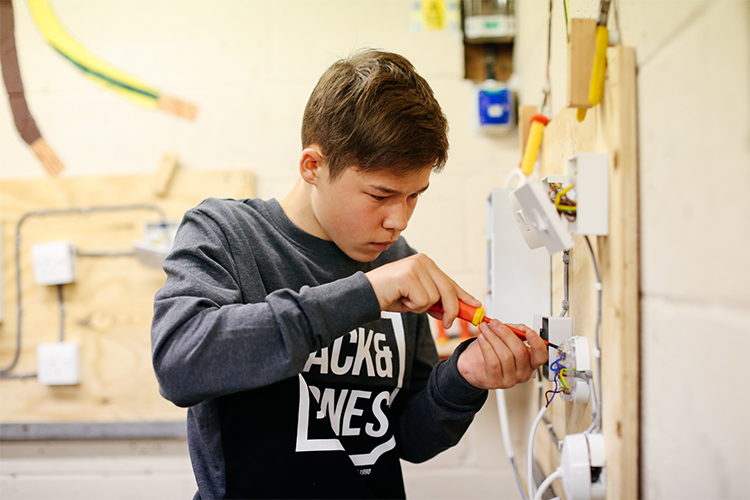 Student fixing a light switch wiring