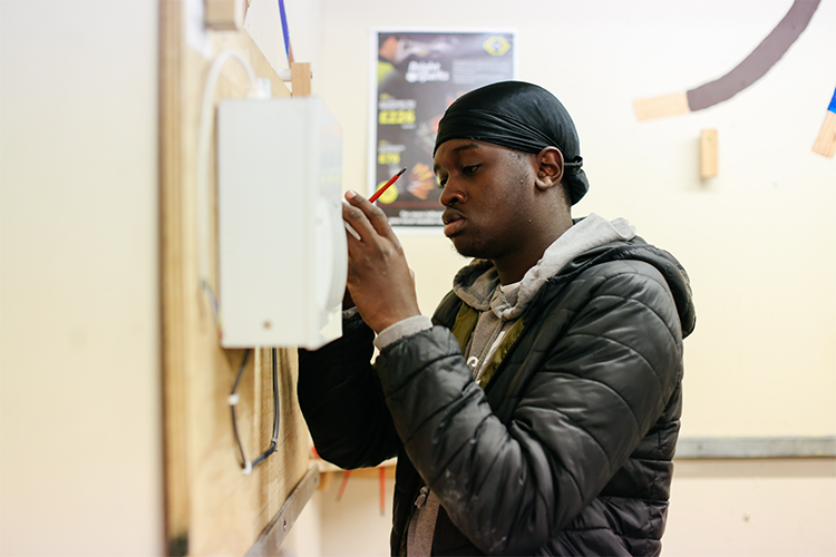 Student fixing a light switch wiring