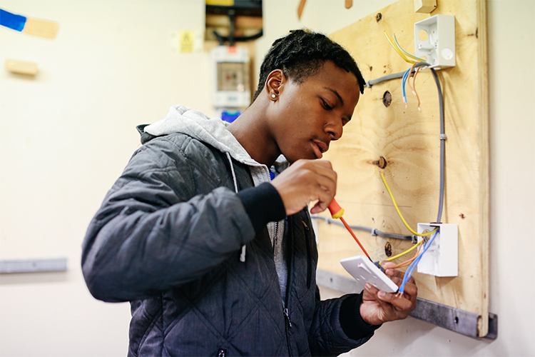 Student fixing a light switch wiring