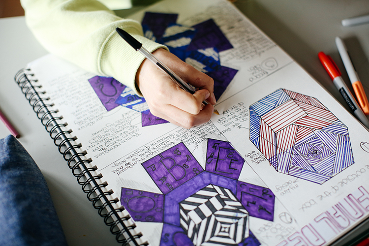Student drawing detailed designs