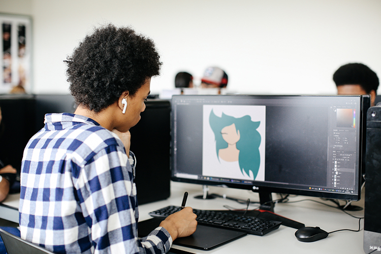 Boy using drawing tablet to design a digital illustration
