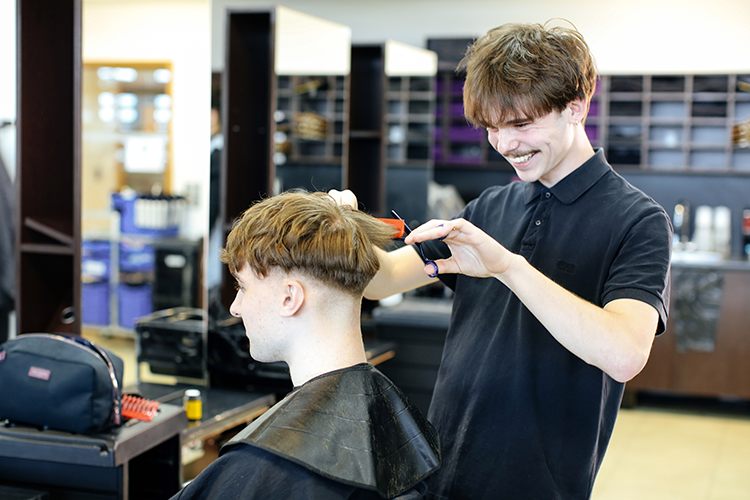 student cutting hair