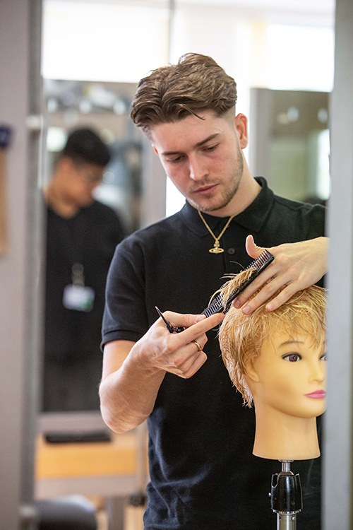 Student cutting mannequin's hair