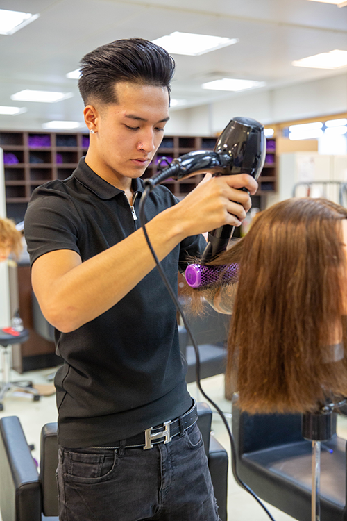 student blowdrying hair
