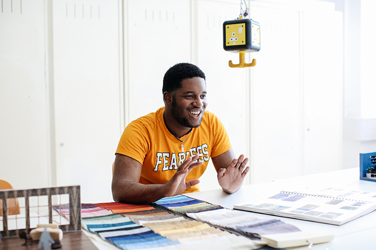 Student talking with fabric swatches 