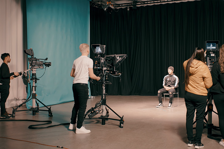 Three groups of students filming another student