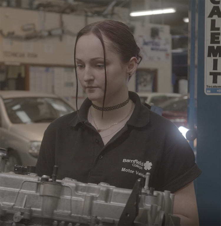 student looking at car engine