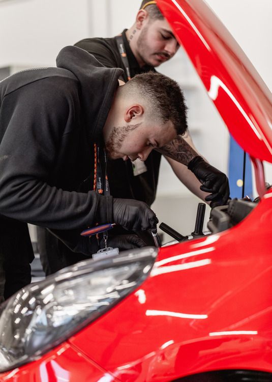 Student checking car oil levels