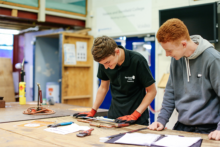 Two students measuring pipe length