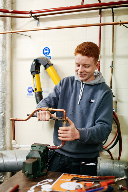 Student fixing pipes together