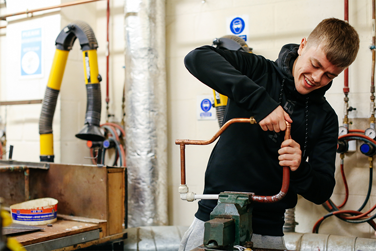 Student fixing pipes together