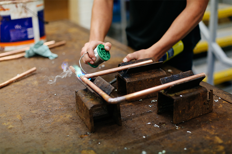 Student fixing pipes together
