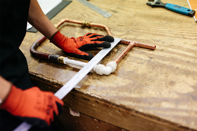 Student fixing pipes together