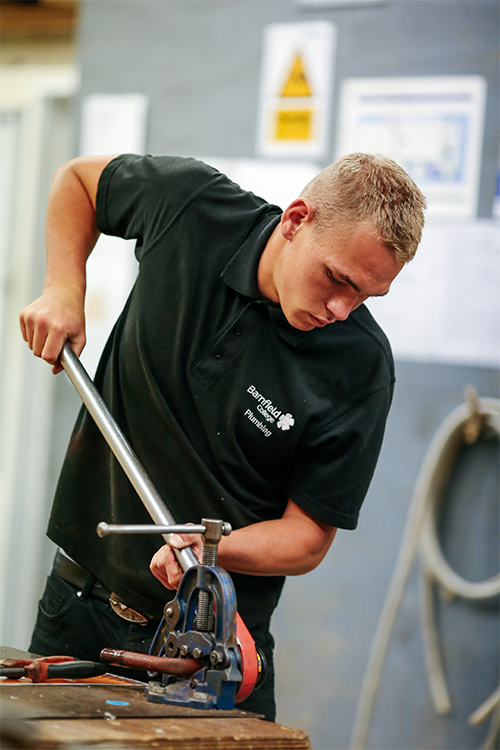 Student fixing pipes together
