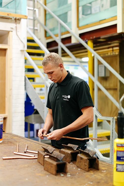Student fixing pipes together