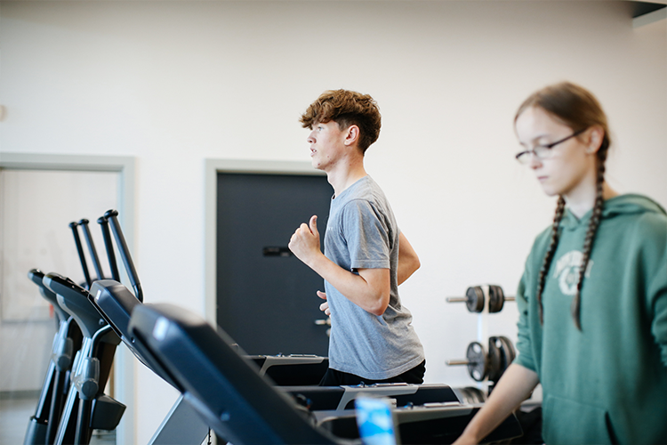 Two students running on a treadmill