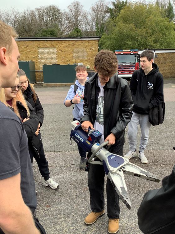 students looking at firefighter equipment
